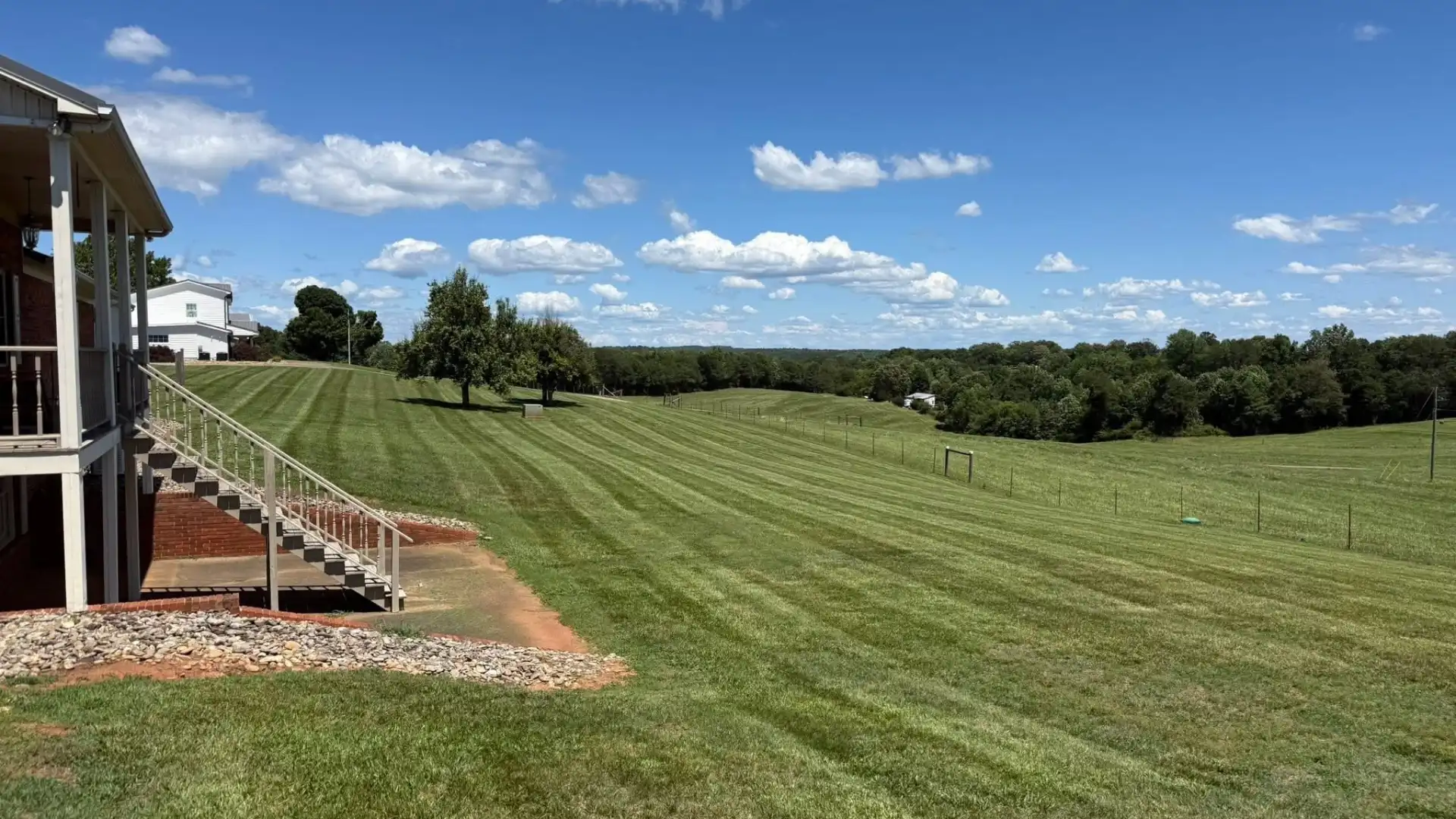 Striped hillside lawn beside a porch